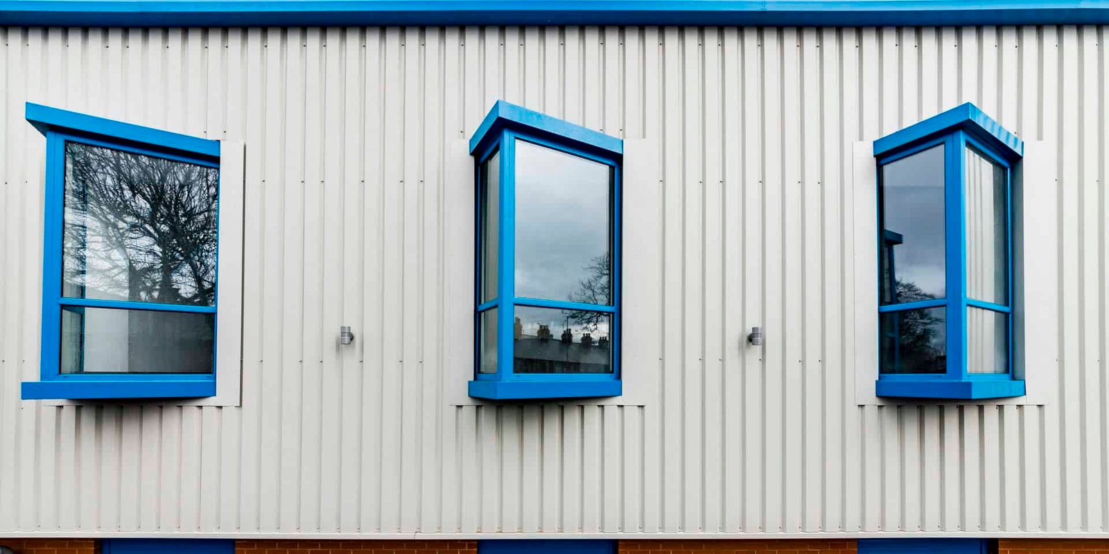 Three windows on the side of a building.