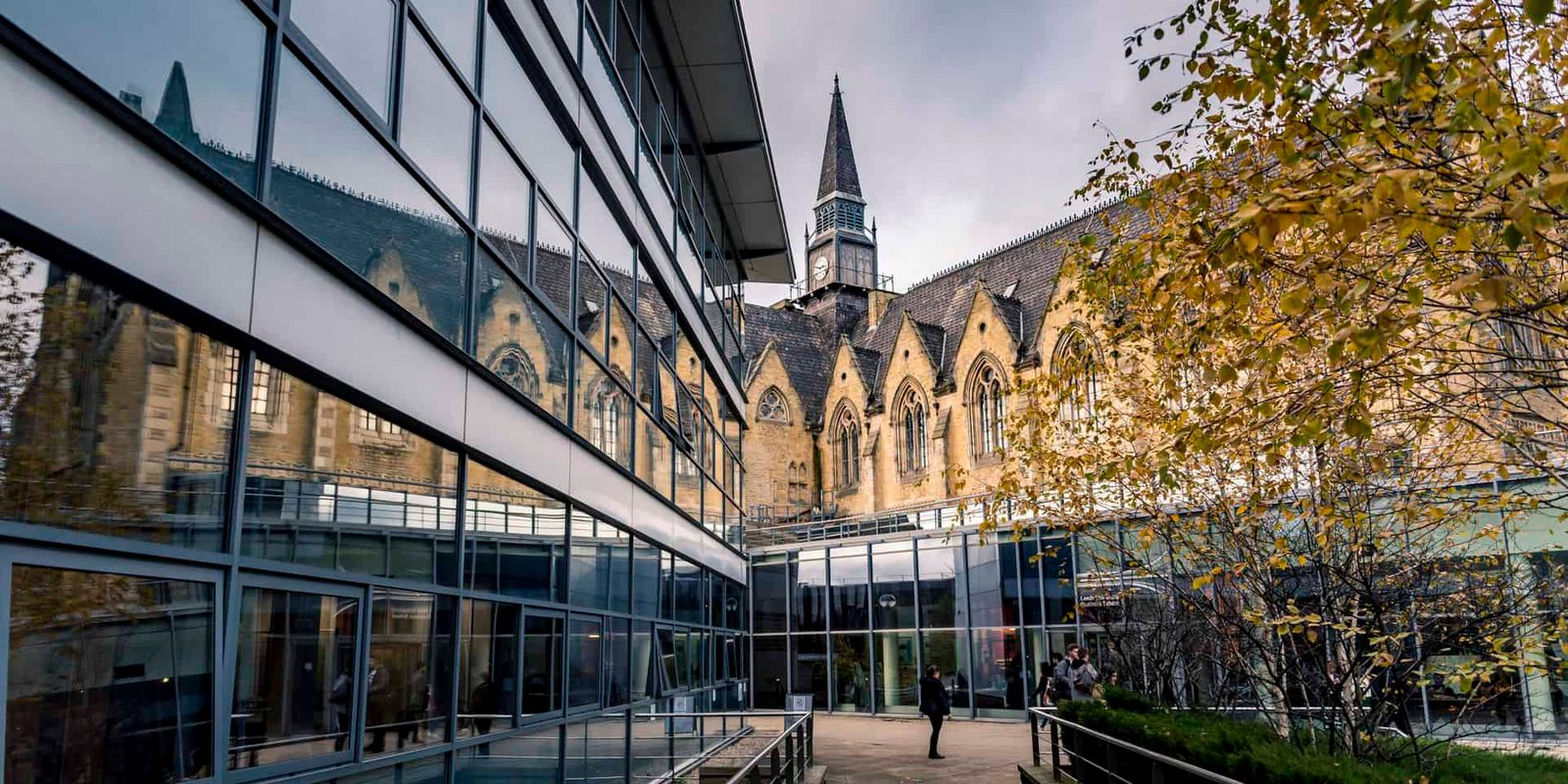 A glass building with a cathedral in the background.