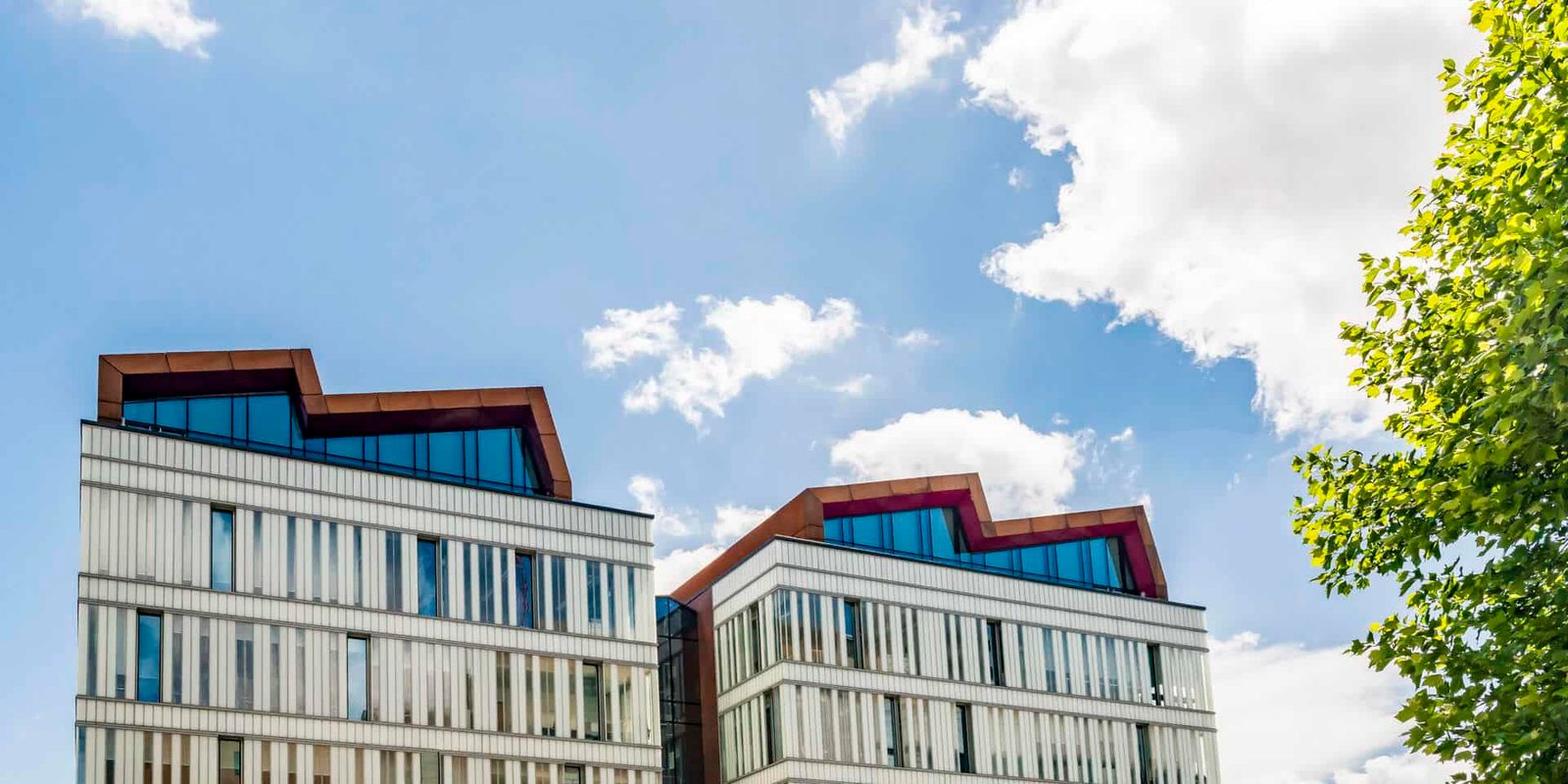 Two buildings with a blue sky behind them.