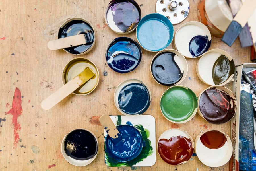 A variety of paints and brushes on a table.