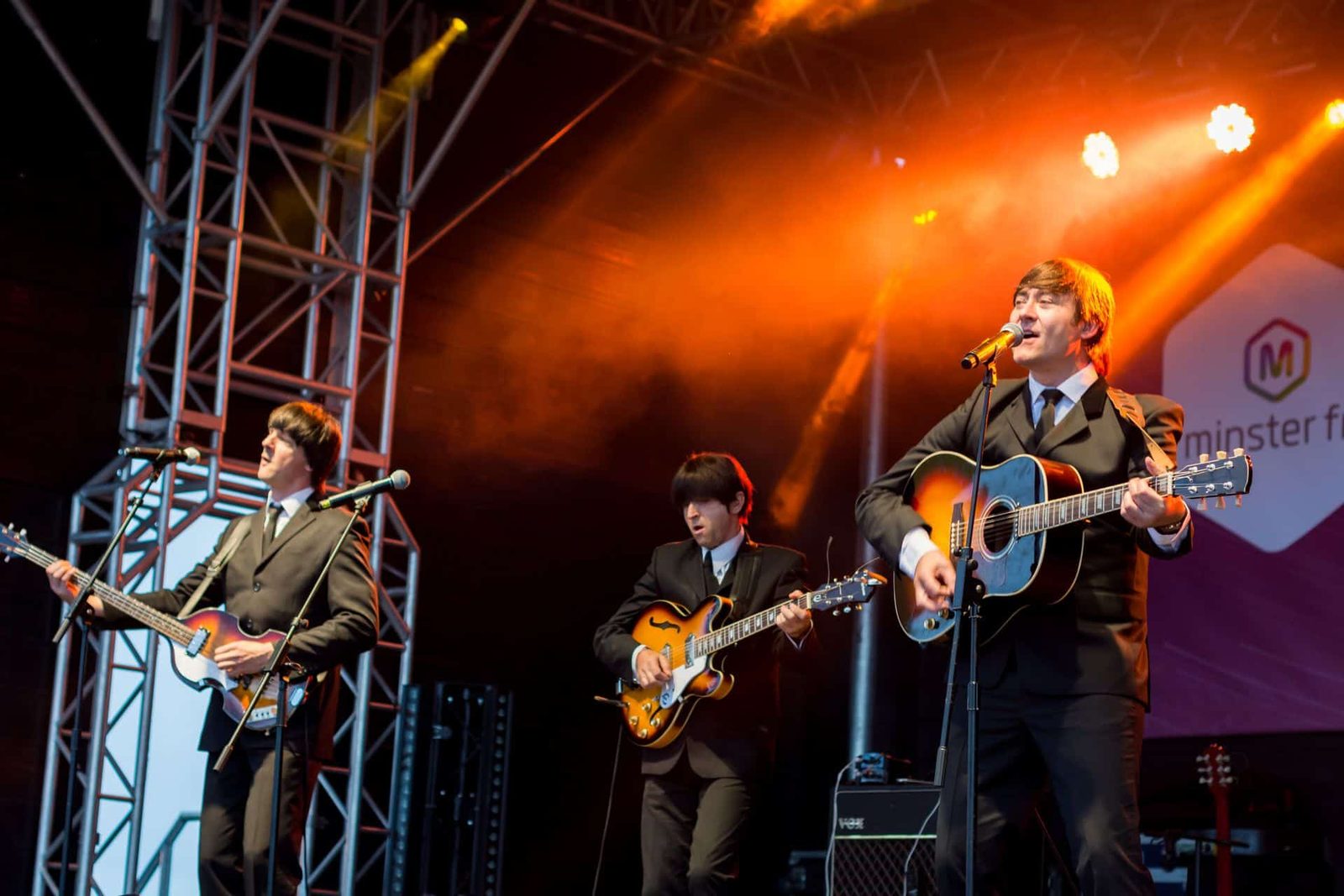 The beatles are performing on stage.