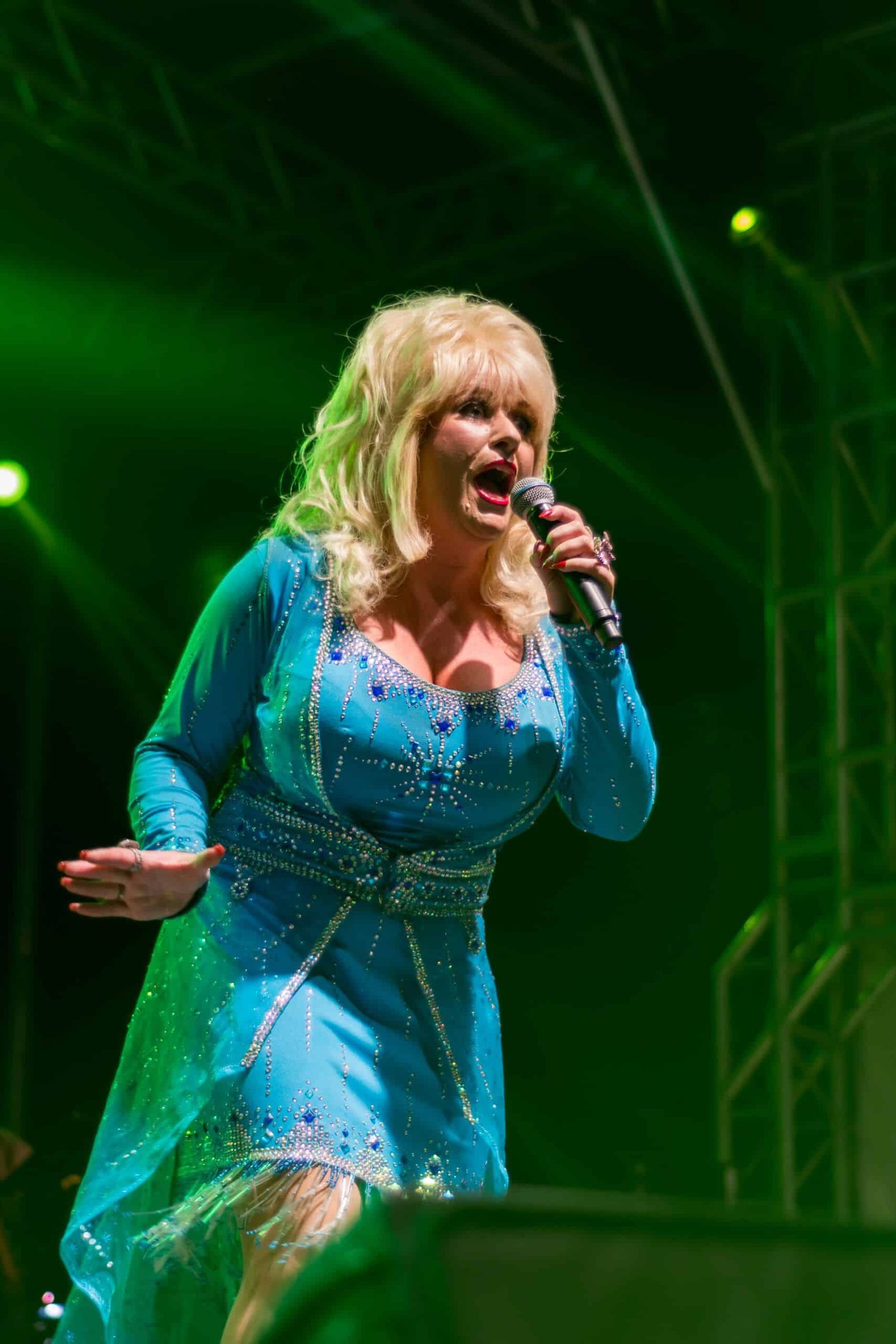 A woman in a blue dress singing into a microphone.