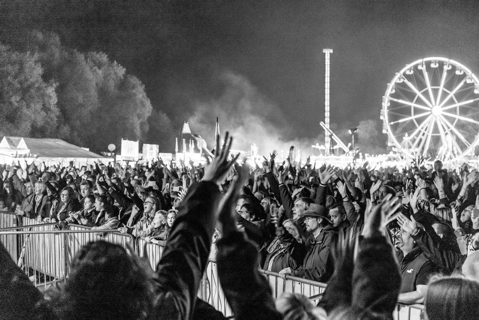 A black and white photo of a crowd at an amusement park.