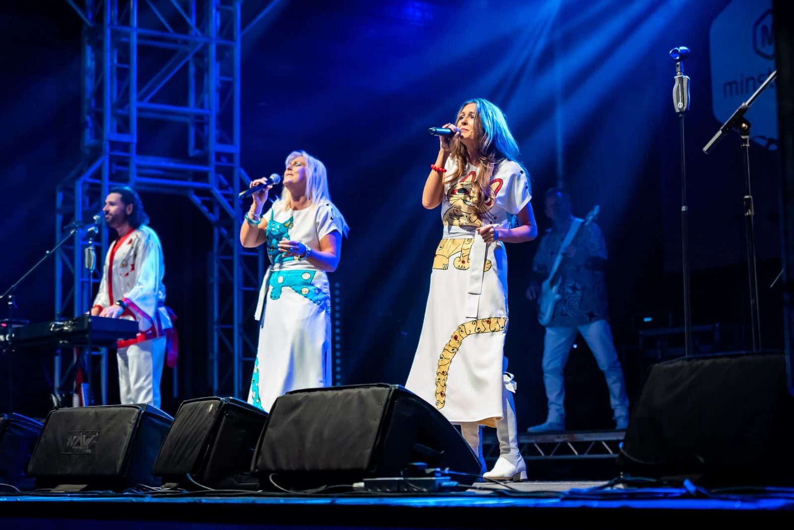 A group of people singing on stage at a concert.