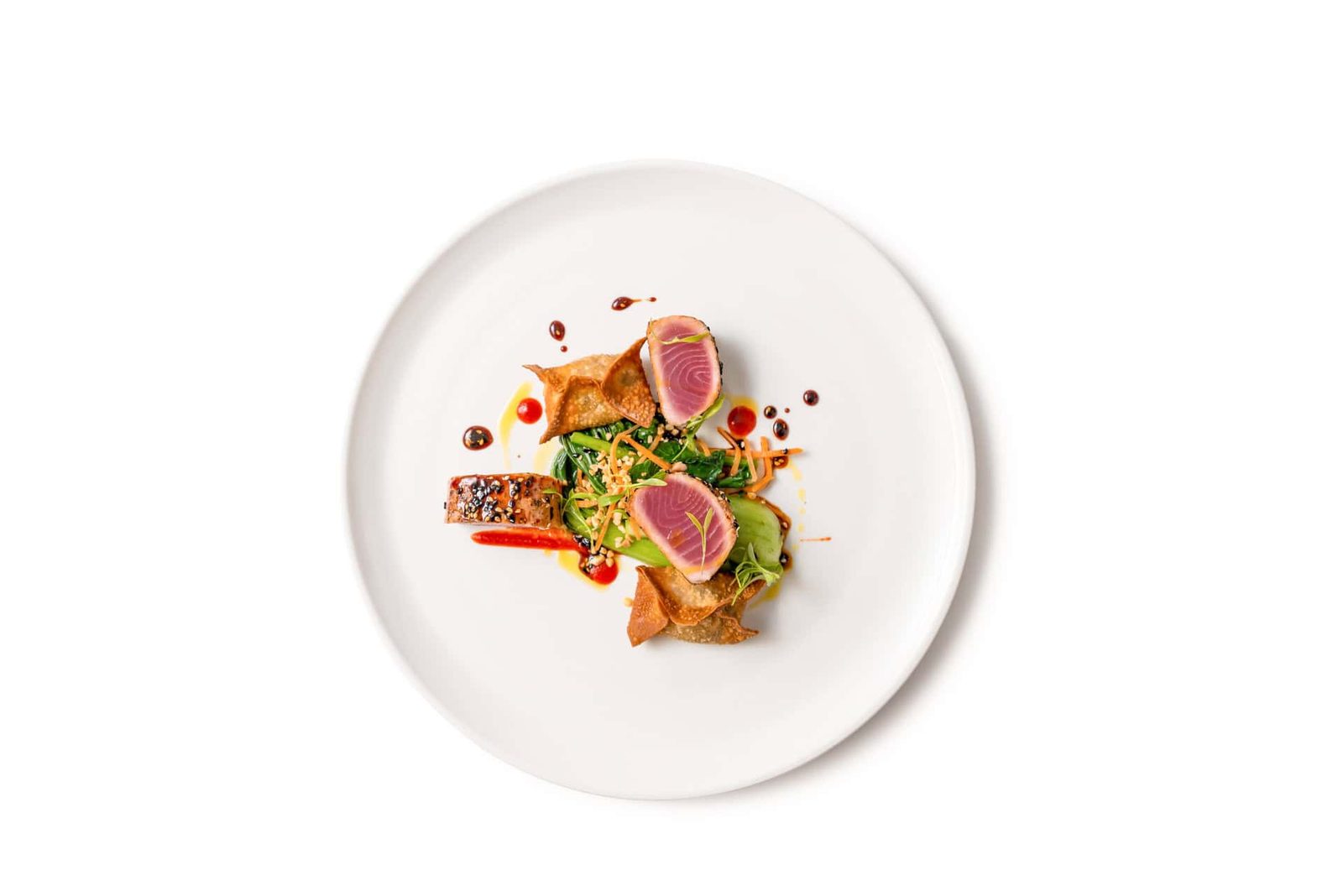 A plate with tuna and vegetables on it.