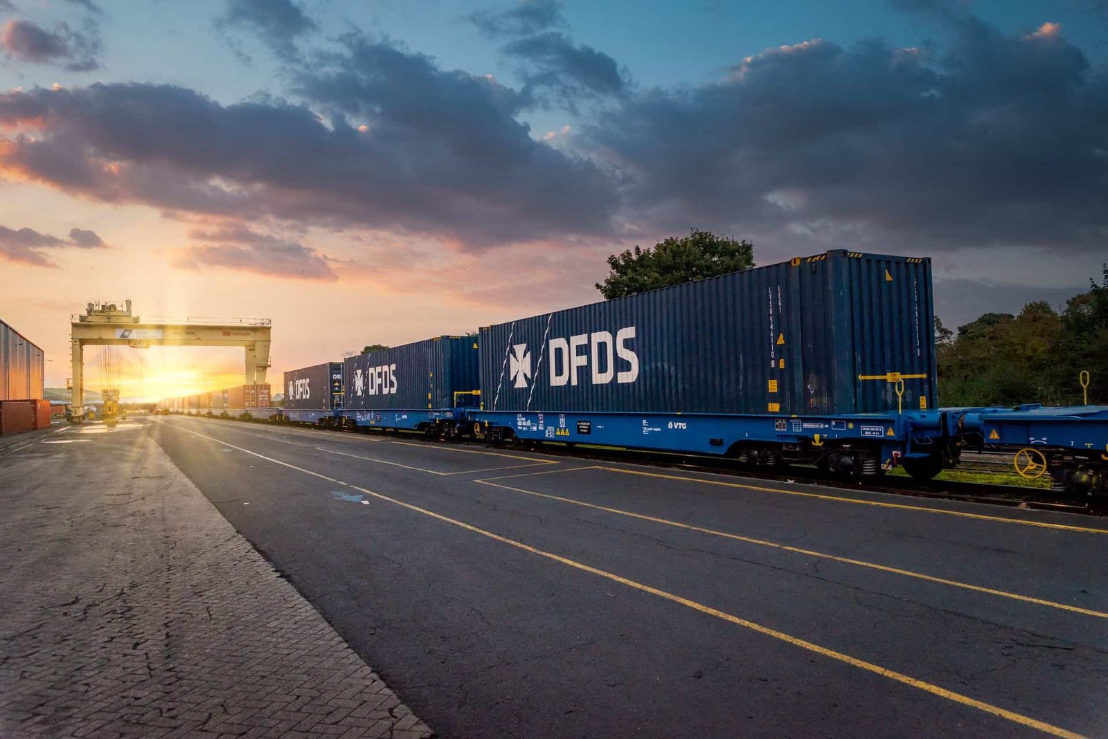 A blue train traveling down a road.