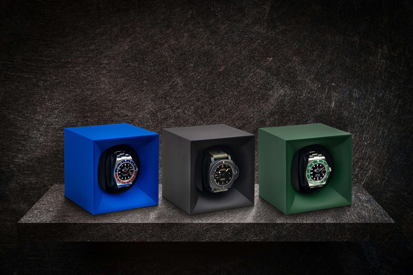 Three watches in a black box on a table.