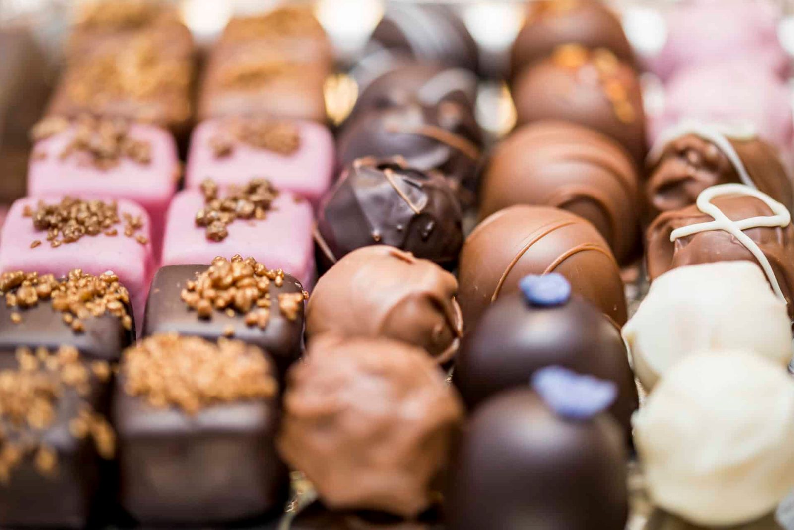 A variety of chocolates are arranged on a silver tray.