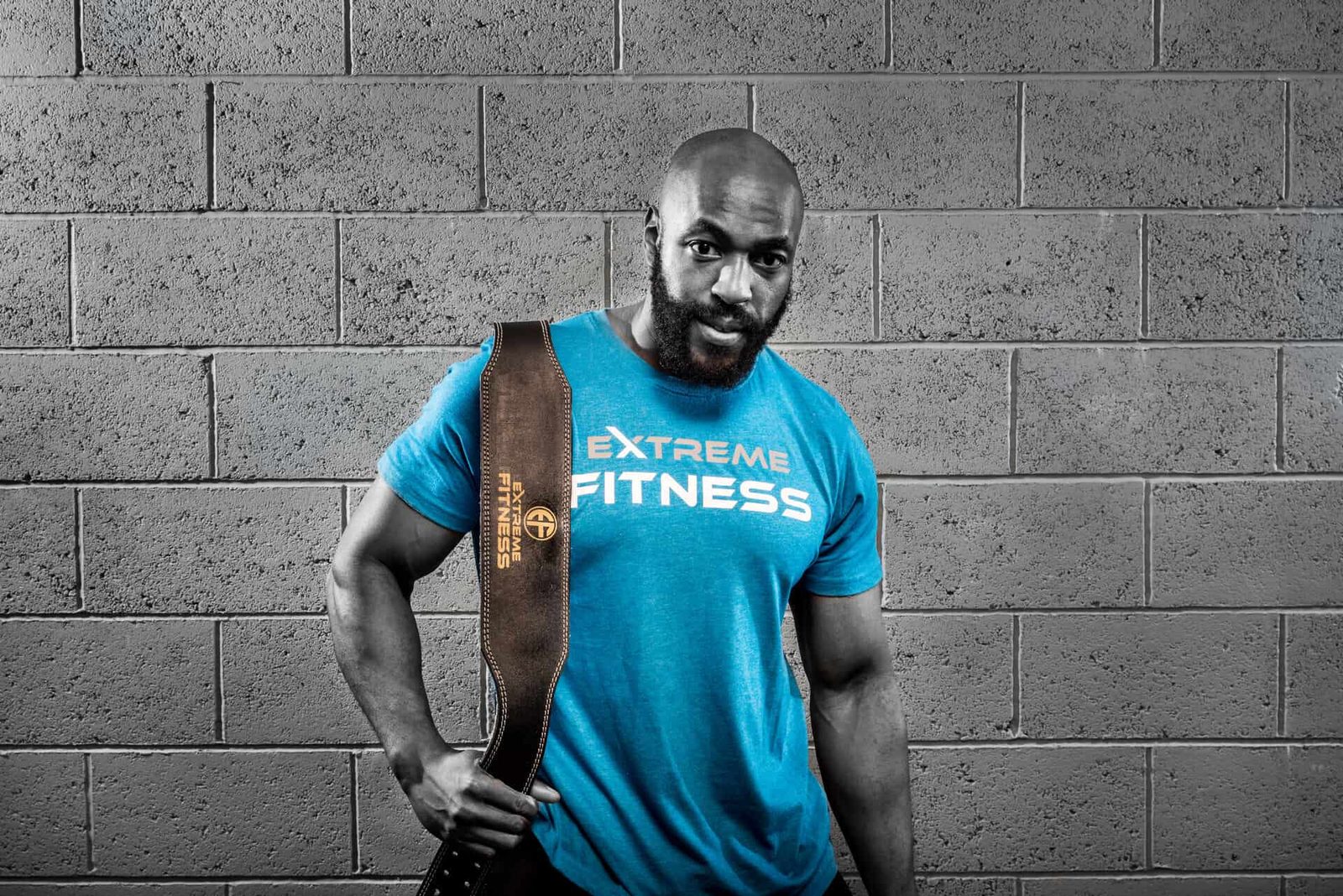 A man in a blue t - shirt holding a blue bag.