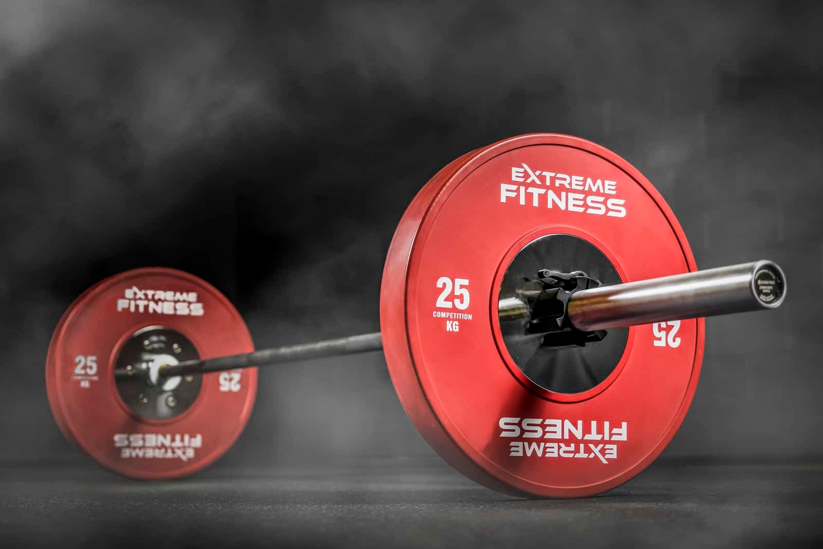 A red barbell on a black background.