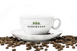 A cup of coffee with darkwoods coffee beans on it.