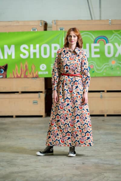 A woman in a dress standing in a warehouse.