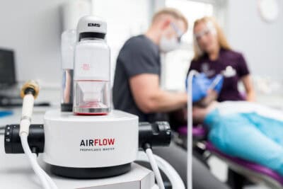 An airflow machine is being used in a dentist's office.