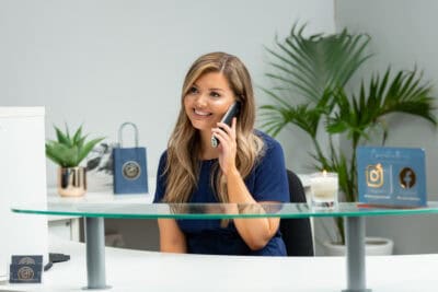 A woman sitting at a desk talking on the phone.