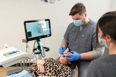 A woman is being examined by a dentist in a dental office.
