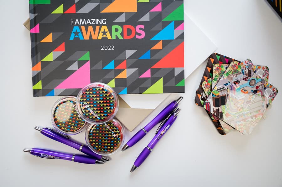 A notebook, pens, and a purple pen on a table.