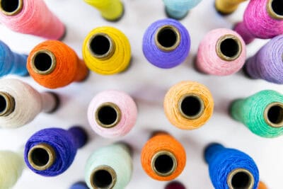 Colorful spools of thread on a white background.