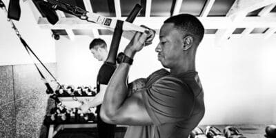 Black and white photo of a man working out in a gym.