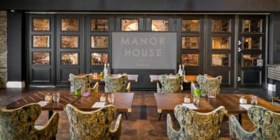 A restaurant with chairs and a sign that says manor house.