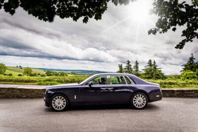 A rolls royce phantom parked on the side of a road.