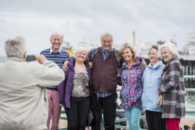 A group of older people posing for a photo on a pier.