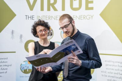Two people looking at a brochure about the internet energy.