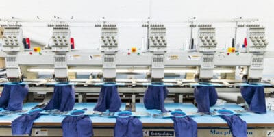 An embroidery machine with blue threads on it.