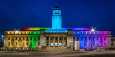Birmingham city council building lit up in rainbow colors.
