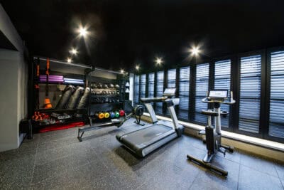 A gym room with a tread machine and other equipment.