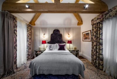 A bed in a room with wooden beams.