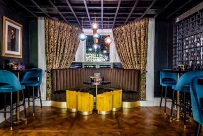 A black and gold bar with blue velvet stools.