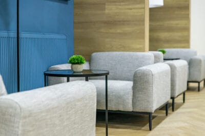 A row of chairs in a lobby with blue walls.