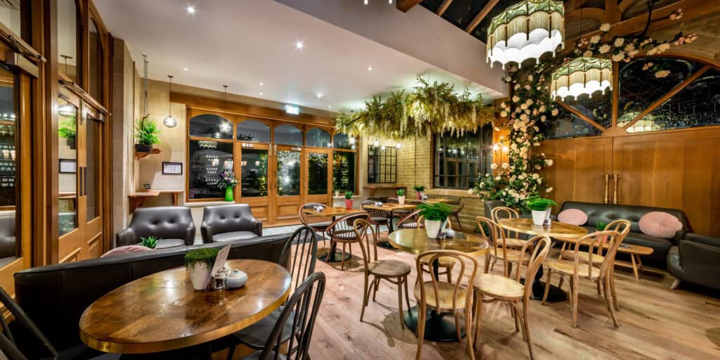 The interior of a restaurant with wooden tables and chairs.