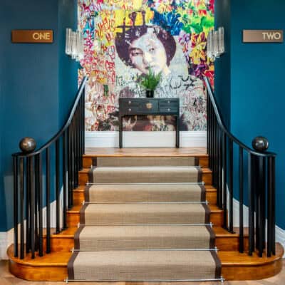 A staircase leading to a room with a mural on the wall.
