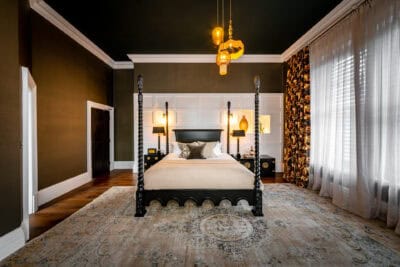 A black and gold bedroom with a four poster bed.