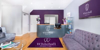 The reception area of a dental office with purple walls.