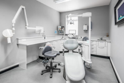 A dentist's office with a white desk and chair.