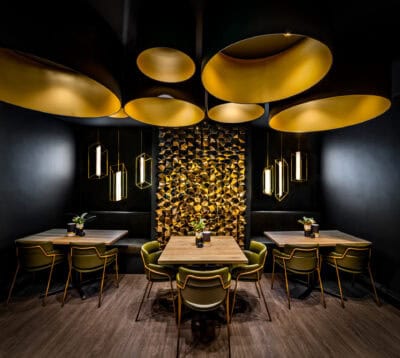 A black and yellow restaurant with tables and chairs.