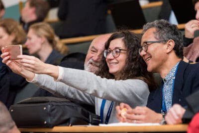 A group of people taking a selfie in a lecture hall.