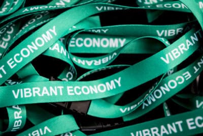 A pile of green lanyards with the words vibrant economy.
