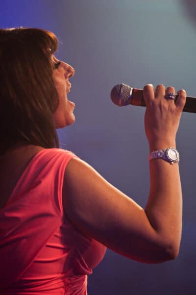 A woman singing into a microphone.