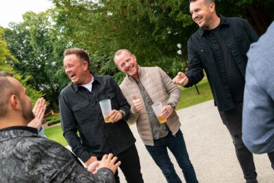 A group of men are laughing in a park.