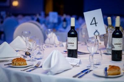 A white tablecloth with wine bottles on it.