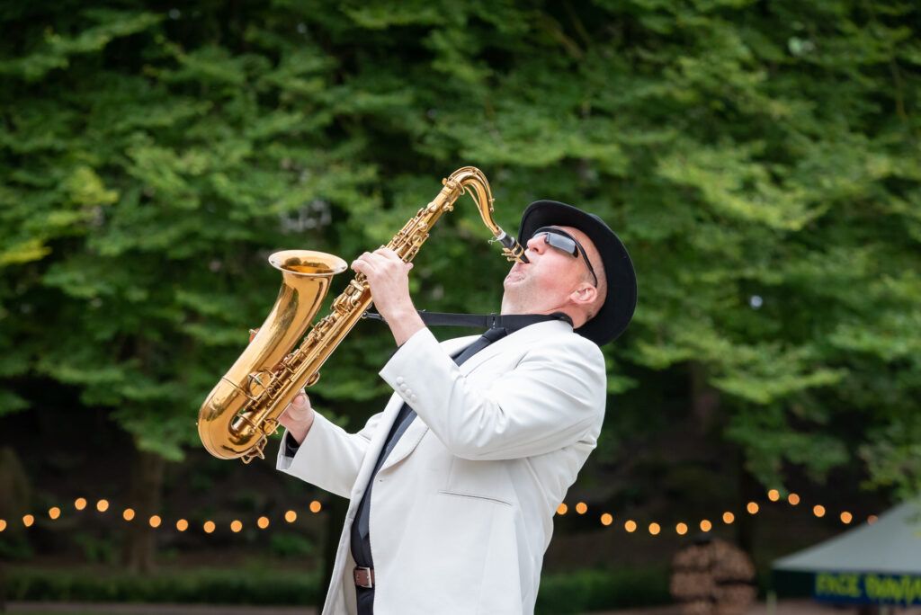 A man playing a saxophone outdoors.