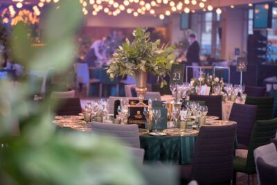 A banquet table set up with green and white tablecloths.