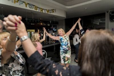 A group of people dancing at a birthday party.