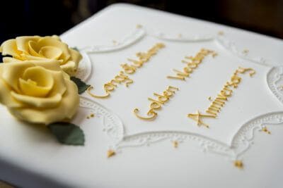 A white cake with yellow roses on it.