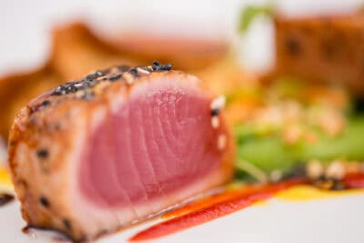 A piece of tuna on a white plate.