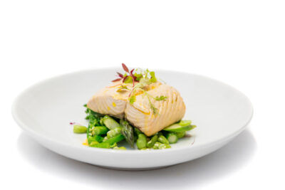 A white plate with salmon and asparagus on it.