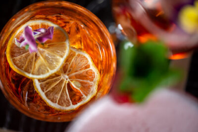 A close up of a cocktail with a slice of lemon.